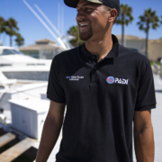 Young guy wearing a Padi black t-shirt, with written Open Water Scuba instructor.