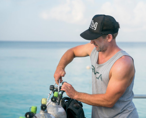 diving instructor securing a nitrox tank before starting the advanced open water diver course