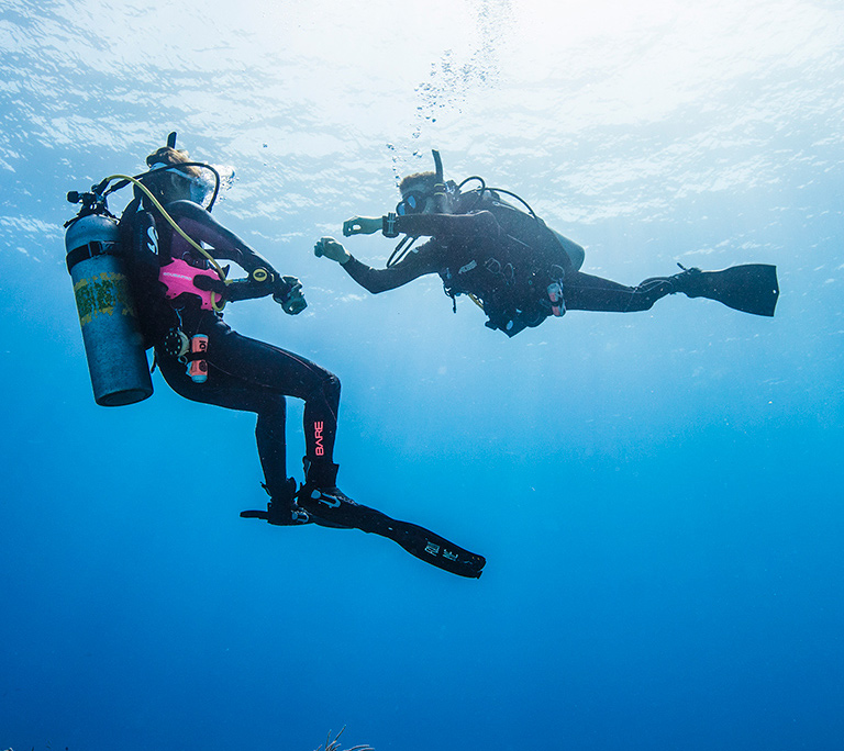 Scuba diving instructor training a beginner diver in the sea in south Spain